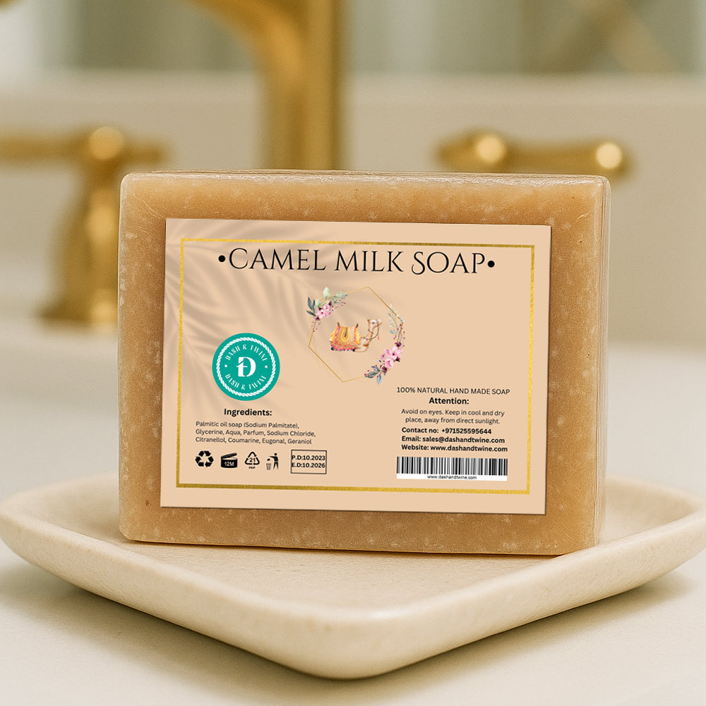 Camel Milk handmade beige soap bar with printed label, wrapped in clear packaging and placed on a white countertop with soft background