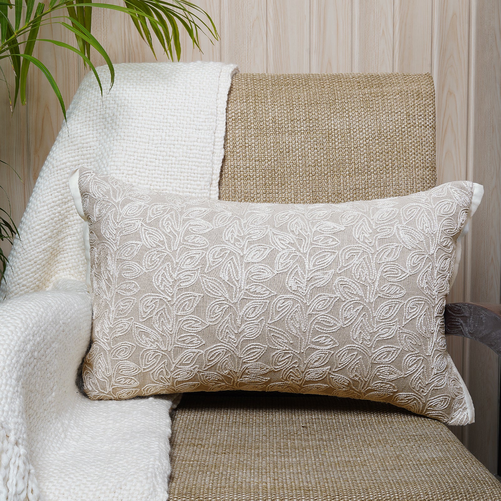 Neutral-toned rectangular cushion with white thread leaf embroidery on chambray fabric