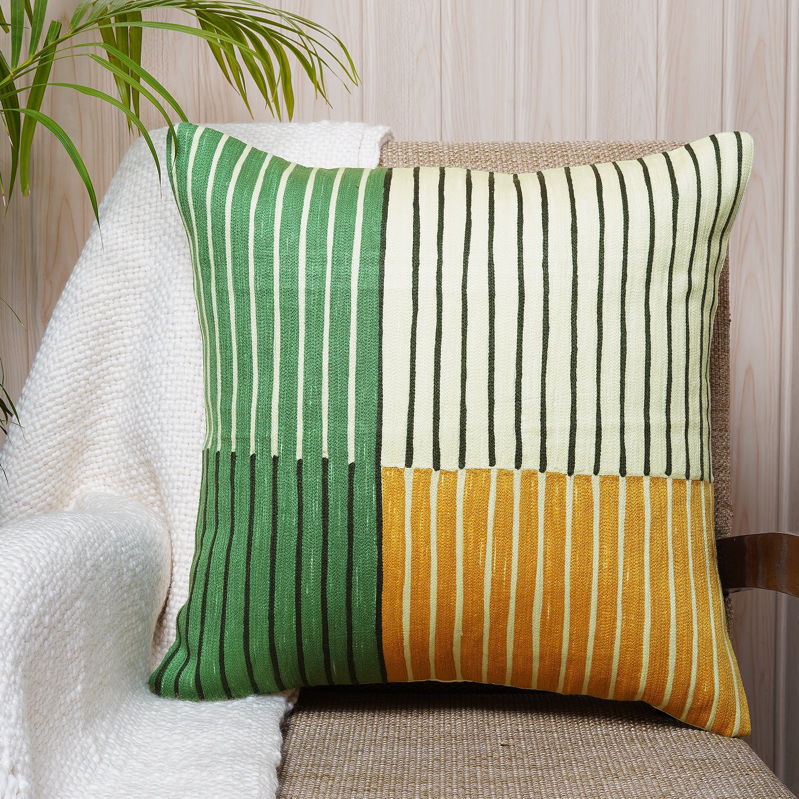 Colour-block cushion with green, cream, and mustard embroidered stripes on cotton fabric